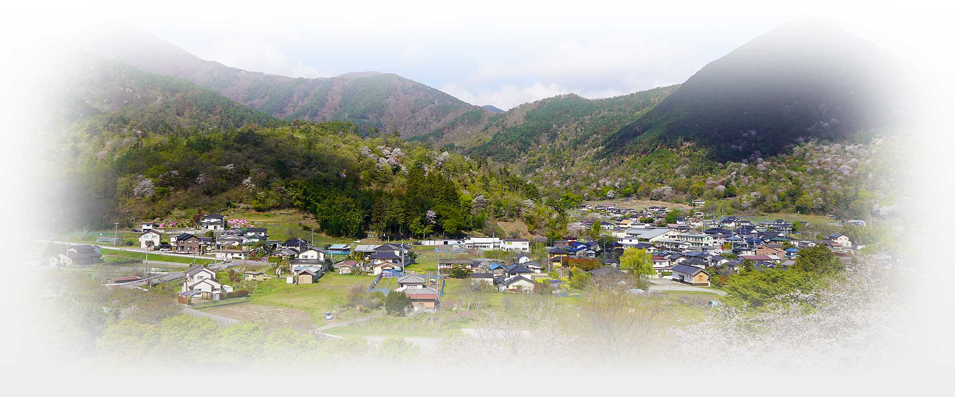 有限会社山岸製作所の社屋外観と里山風景